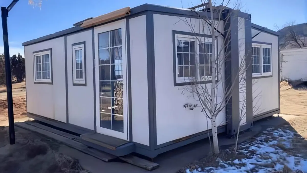 Steel-frame expandable cabin at sunset for wildfire and climate-resilience planning